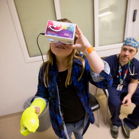 TORONTO, ON - FEBRUARY 14  - 
Tess Baird uses the VR headset while Dr. Ben O'Sullivan looks on. 

Virtual Reality isn't just for gamers. A new project between SickKids and Sunnybrook uses VR headsets to ease pre-surgery anxiety. Patients watch immersive video of the surgery process: wheeled down the hallway, getting anaesthesia, waking up. Pre-surgery anxiety has affects that spill over even after surgery.        (Carlos Osorio/Toronto Star via Getty Images)