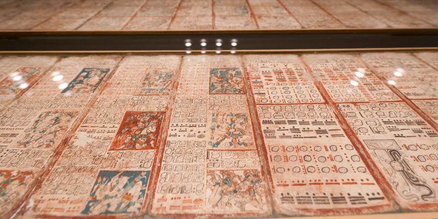 The historic Maya manuscript 'Codex Dresdensis' is displayed under glass at the museum attached to Saxony's federal library (Saechischen Landesbibliothek) on February 22, 2012 in Dresden, eastern Germany. The 13th century piece is considered one of the world's oldest books. The manuscript was purchased for the museum in Vienna in 1739 as a 'Mexican Book'. It was identified as a Maya manuscript only in 1853. The book is composed of 39 bast fibre pages, which are double-sidedly inscribed and adds up to an overall length of 3.56 metres. The Codex comprises hieroglyphics, numbers and pictures and holds calendars, accounts on stellar constellation, lunar and solar eclipses as well as weather forecasts. Only few of the 750 signs include have been identified so far. The special exhibition "The end of the world in 2012?, The Dresden Maya Code and its deciphering" takes place from 24th of February until 12th of May 2012. AFP PHOTO / ROBERT MICHAEL (Photo credit should read ROBERT MICHAEL/AFP via Getty Images)